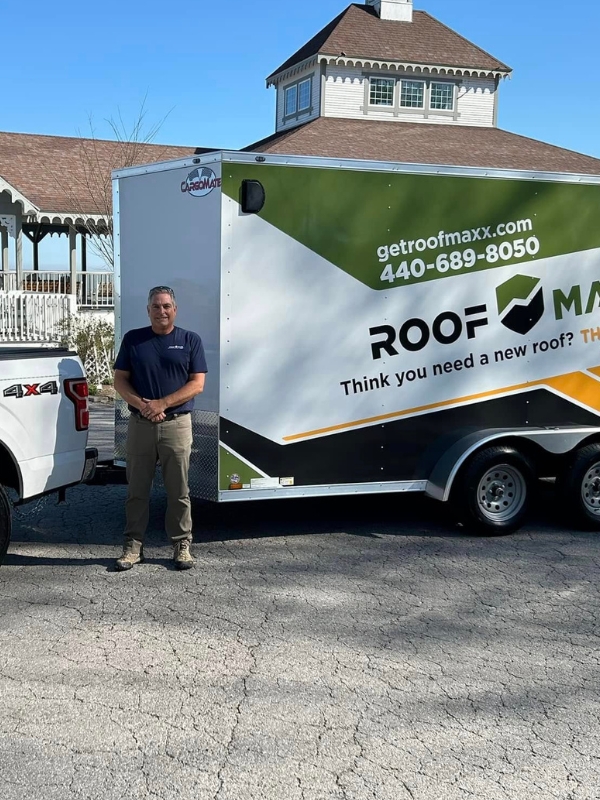 Brett York standing in front of a Roof Maxx trailer.